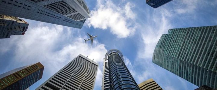 plane flying over buildings